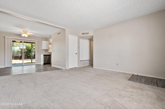 unfurnished living room featuring carpet flooring, visible vents, and baseboards