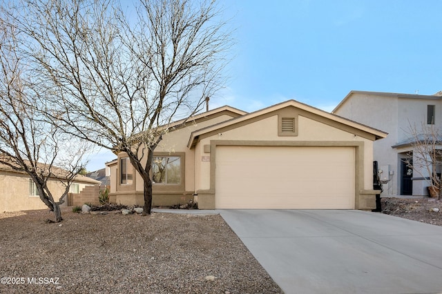 view of front of house featuring a garage, concrete driveway, and stucco siding