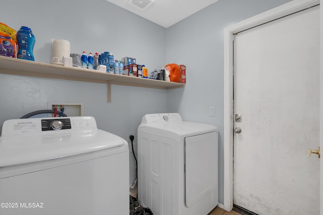 washroom featuring laundry area, visible vents, and separate washer and dryer