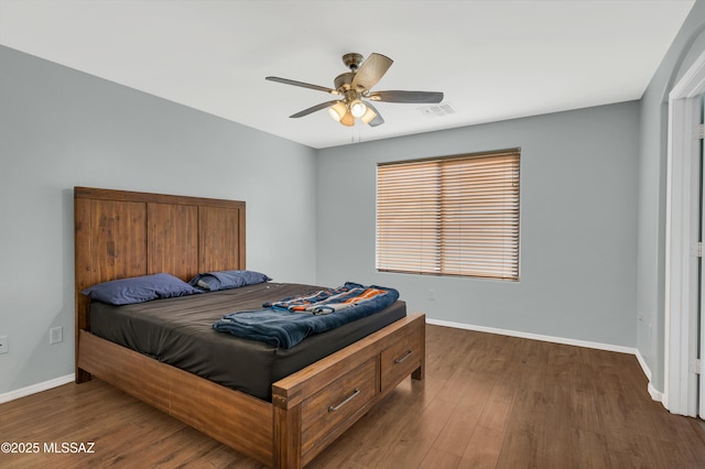 bedroom with ceiling fan, wood finished floors, visible vents, and baseboards