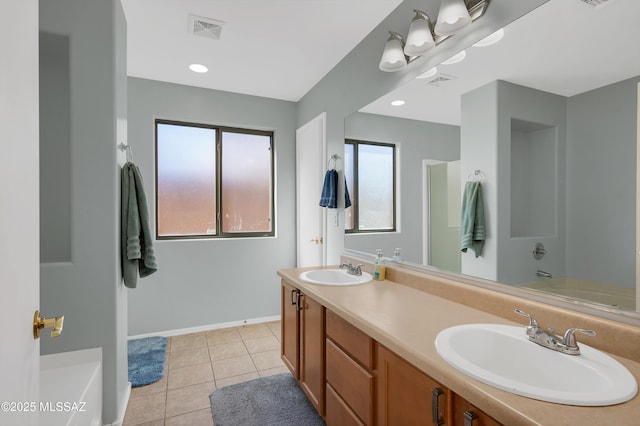 bathroom featuring a tub, visible vents, a sink, and tile patterned floors