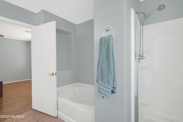 bathroom with a stall shower, tile patterned flooring, visible vents, and a garden tub