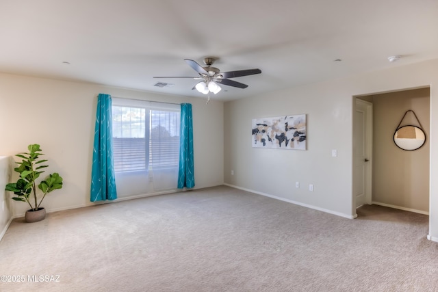 empty room with baseboards, ceiling fan, visible vents, and carpet flooring