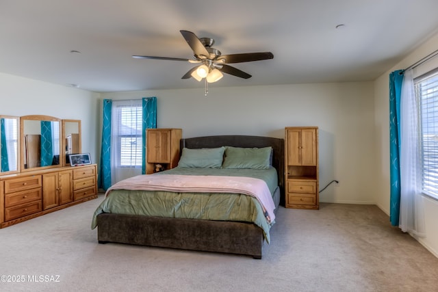 bedroom with ceiling fan and light colored carpet