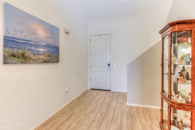 entrance foyer with baseboards and light wood finished floors