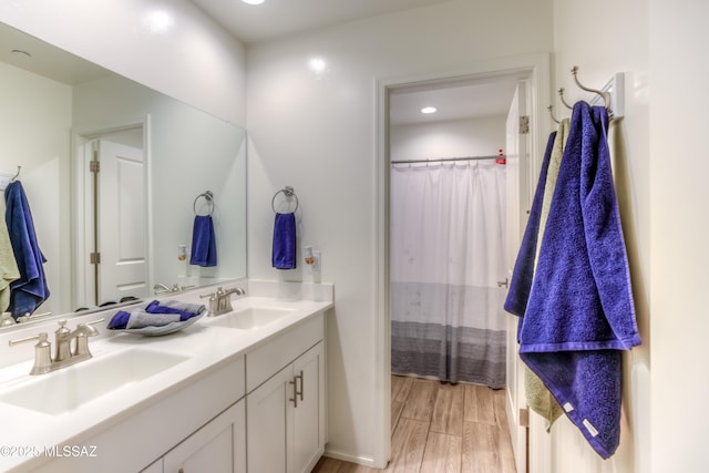 bathroom featuring double vanity, a sink, and wood finished floors