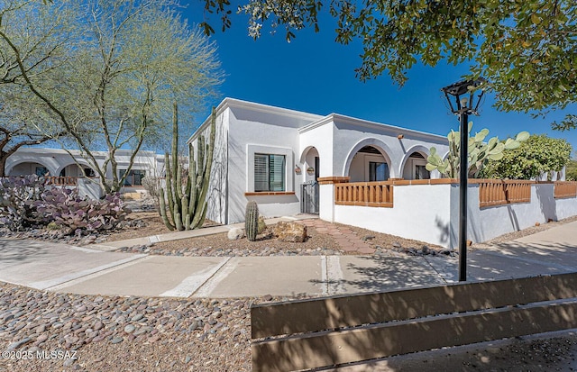 view of front of property with a fenced front yard and stucco siding