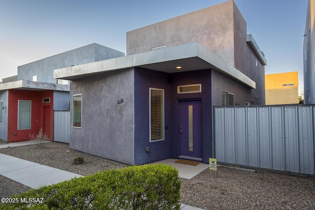 view of front of house featuring fence and stucco siding