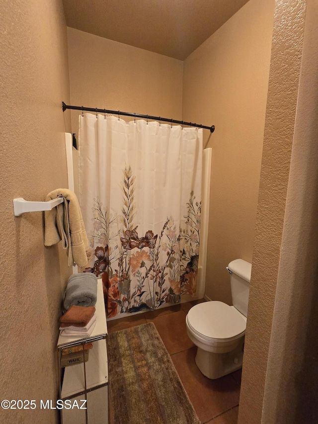 1702 E Saint Bernadine St, Tucson, AZ 85713 - bathroom with toilet, a textured wall, a shower with curtain, and tile patterned flooring