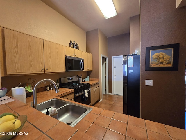 1702 E Saint Bernadine St, Tucson, AZ 85713 - kitchen with gas stove, tile counters, light brown cabinets, freestanding refrigerator, and a sink