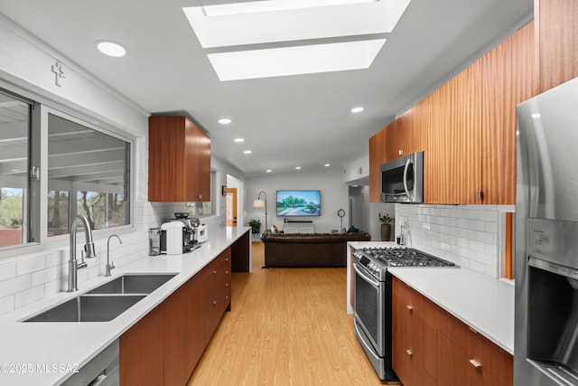 6530 N Camino De La Karina, Tucson, AZ 85718 - kitchen with appliances with stainless steel finishes, a sink, backsplash, light wood finished floors, and open floor plan