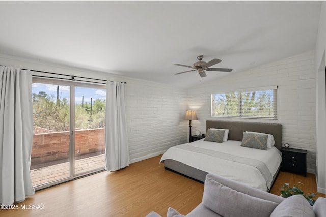 6530 N Camino De La Karina, Tucson, AZ 85718 - bedroom featuring access to outside, lofted ceiling, wood finished floors, multiple windows, and brick wall