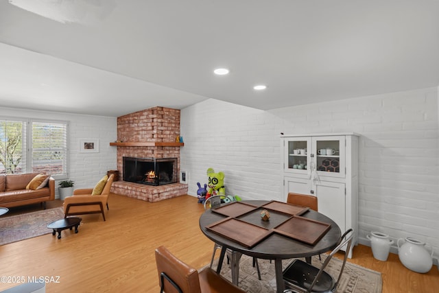6530 N Camino De La Karina, Tucson, AZ 85718 - dining space with light wood-type flooring, a fireplace, and brick wall