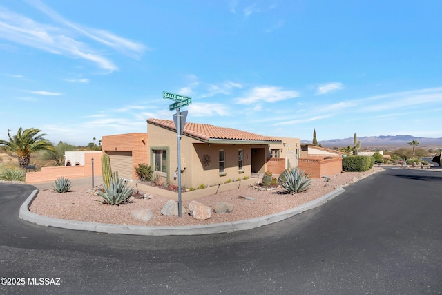 view of front of home featuring a tile roof, a mountain view, and stucco siding