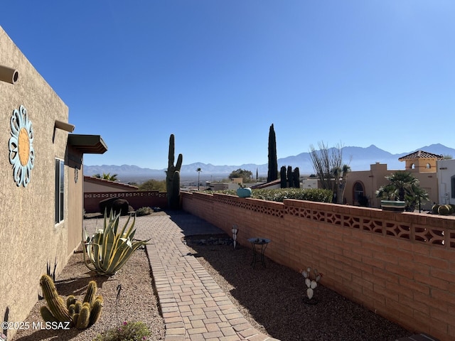 exterior space with a mountain view, fence, and stucco siding