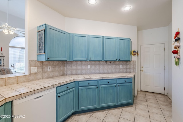 kitchen featuring blue cabinets, tasteful backsplash, and dishwasher