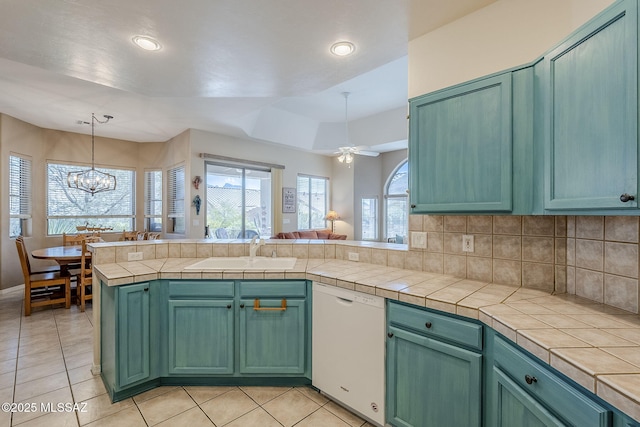 kitchen with light tile patterned flooring, dishwasher, tasteful backsplash, and a sink