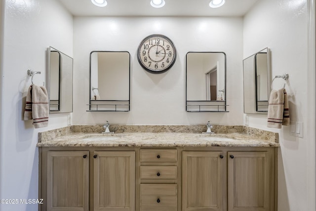 bathroom featuring a sink, recessed lighting, and double vanity