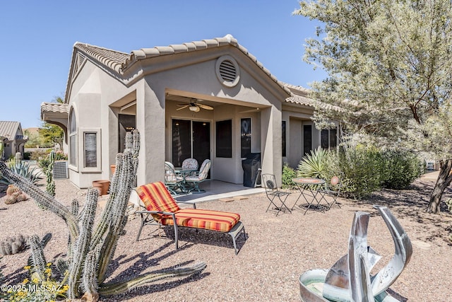 rear view of house featuring a patio area, stucco siding, a tiled roof, and a ceiling fan