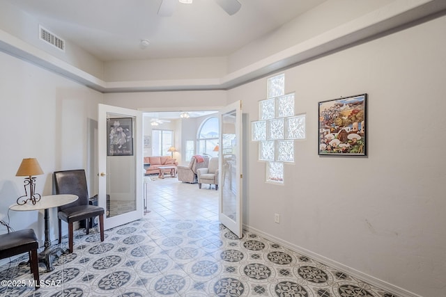 living area featuring light tile patterned floors, visible vents, french doors, and baseboards