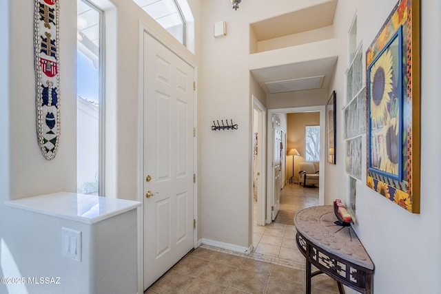 foyer entrance with light tile patterned floors and baseboards