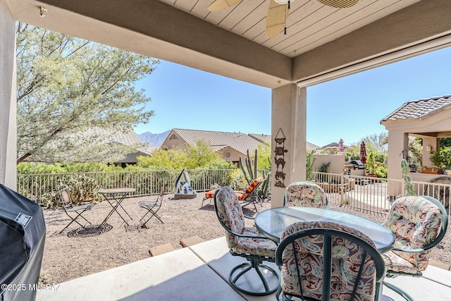 view of patio / terrace with a grill, a ceiling fan, and fence