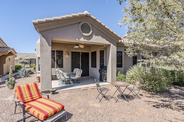 back of property with a patio, a ceiling fan, a tile roof, and stucco siding