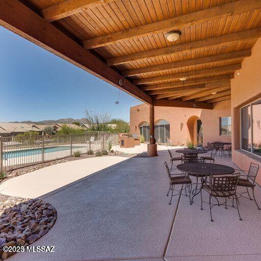 view of patio / terrace with outdoor dining space, a fenced in pool, and fence