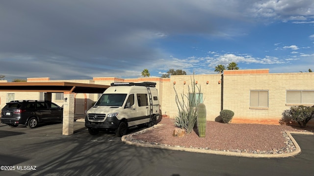 view of front facade with brick siding and covered parking