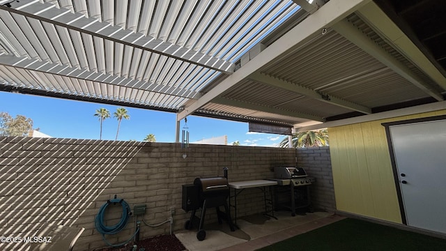 view of patio featuring a grill, a pergola, and fence