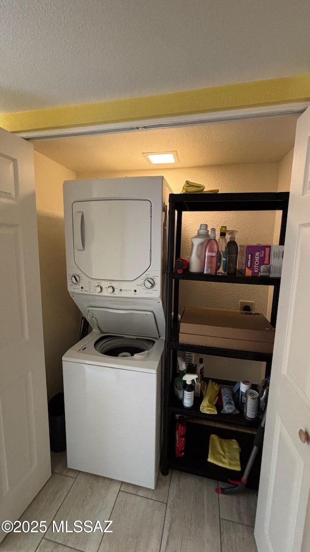 laundry room with stacked washer / drying machine and laundry area