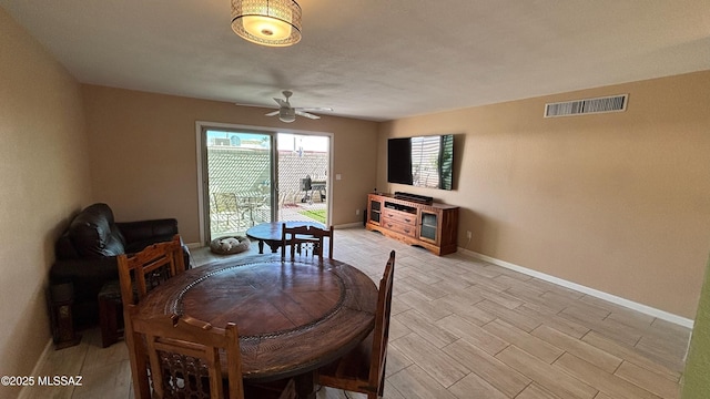 dining area featuring light wood finished floors, visible vents, baseboards, and a ceiling fan