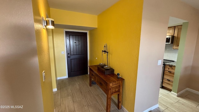 doorway to outside featuring wood finish floors and baseboards