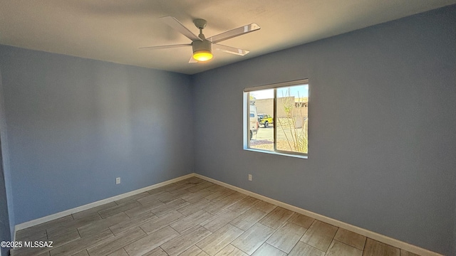 spare room featuring wood finish floors, baseboards, and ceiling fan