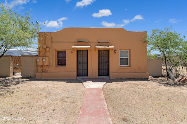 pueblo-style house featuring stucco siding