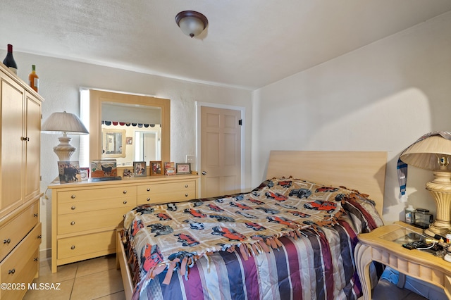 bedroom with light tile patterned floors and a textured wall