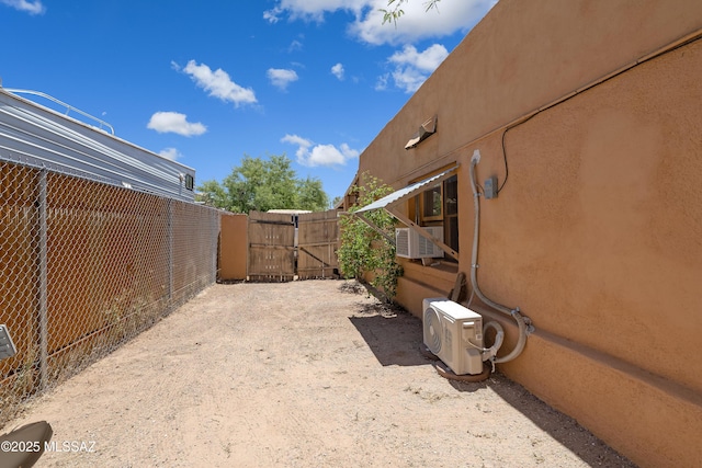 view of yard with ac unit, a gate, fence, and cooling unit