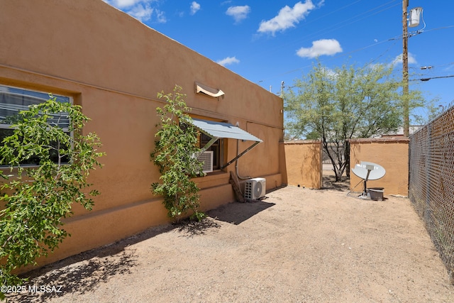 exterior space with ac unit and fence