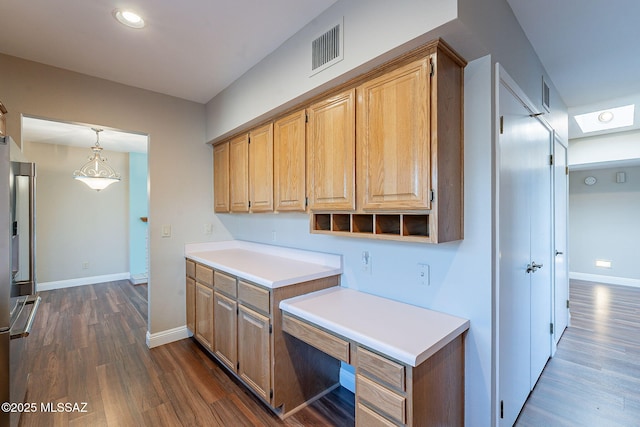 kitchen with light countertops, dark wood-style flooring, and visible vents