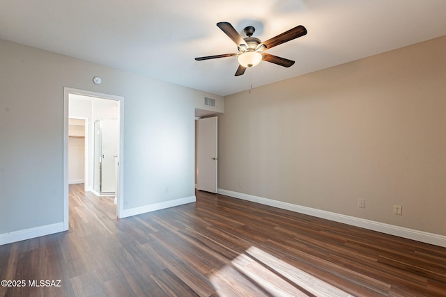 unfurnished bedroom with visible vents, baseboards, ceiling fan, dark wood-style floors, and a walk in closet