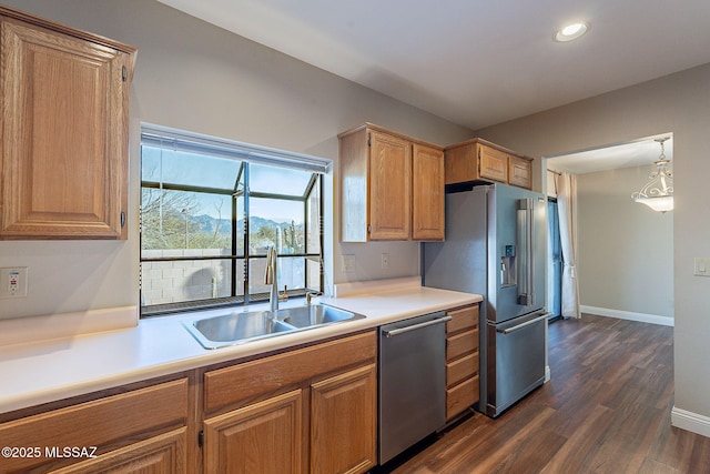 kitchen featuring light countertops, a sink, stainless steel appliances, and dark wood-type flooring