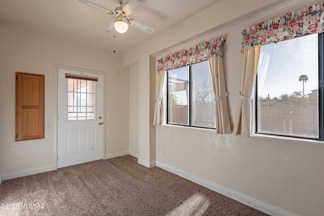 interior space with baseboards, carpet flooring, and a ceiling fan