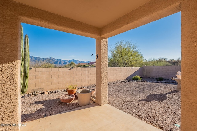 view of yard with a patio, a mountain view, and a fenced backyard