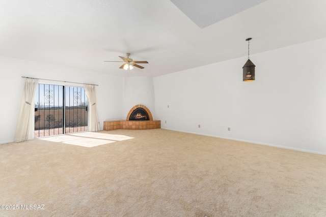 unfurnished living room featuring carpet flooring, baseboards, ceiling fan, and a fireplace