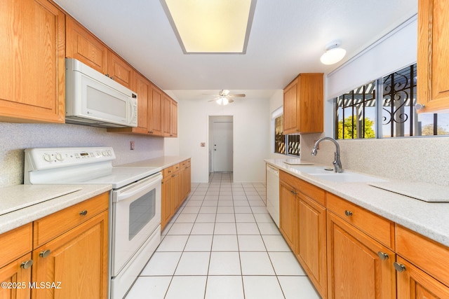 kitchen featuring a ceiling fan, a sink, white appliances, light countertops, and light tile patterned floors