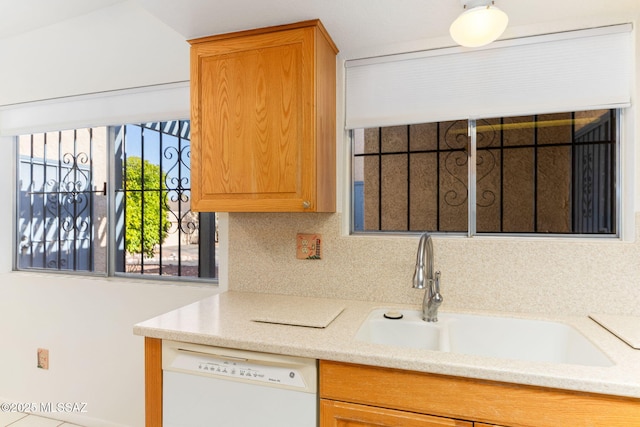 kitchen featuring a sink, light stone counters, tasteful backsplash, and dishwasher