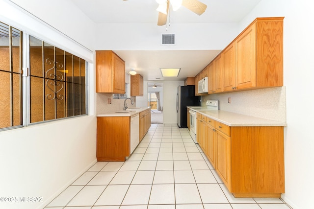 kitchen featuring light tile patterned floors, visible vents, white appliances, and light countertops