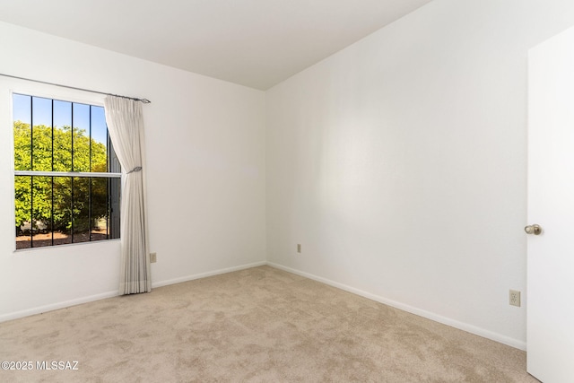 unfurnished room featuring carpet and baseboards