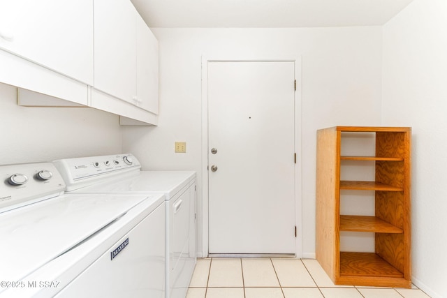 laundry area featuring light tile patterned floors, cabinet space, and washer and clothes dryer