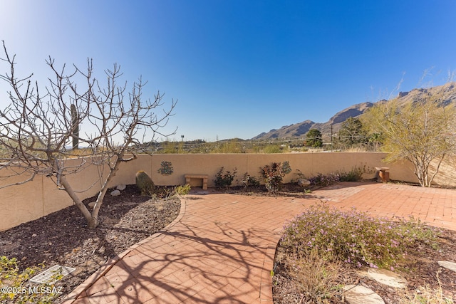 view of patio featuring a mountain view and a fenced backyard